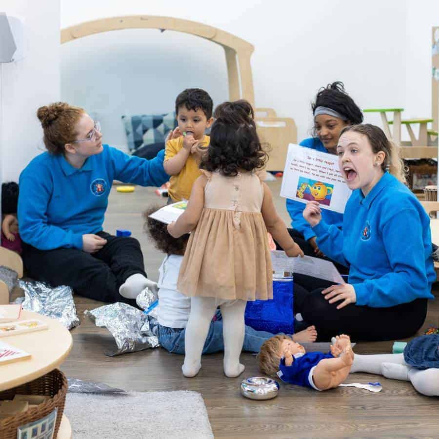 Childcare activities at Monkey Puzzle Day Nurseries with young children and caregivers engaging in storytelling and play, promoting early childhood development.